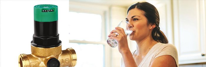 Ein Druckminderer der Pb Frei ist, rechts im Bild ist eine Frau in der Küche und Trinkt ein Glas Wasser