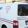 Fahrzeug des Sanitär- und Heizungsdienstes in der Stadt Der Lieferwagen von 'Tilgner' ist mit Informationen zu Dach- und Sanitärdiensten beschriftet und parkt vor einem historischen Gebäude.